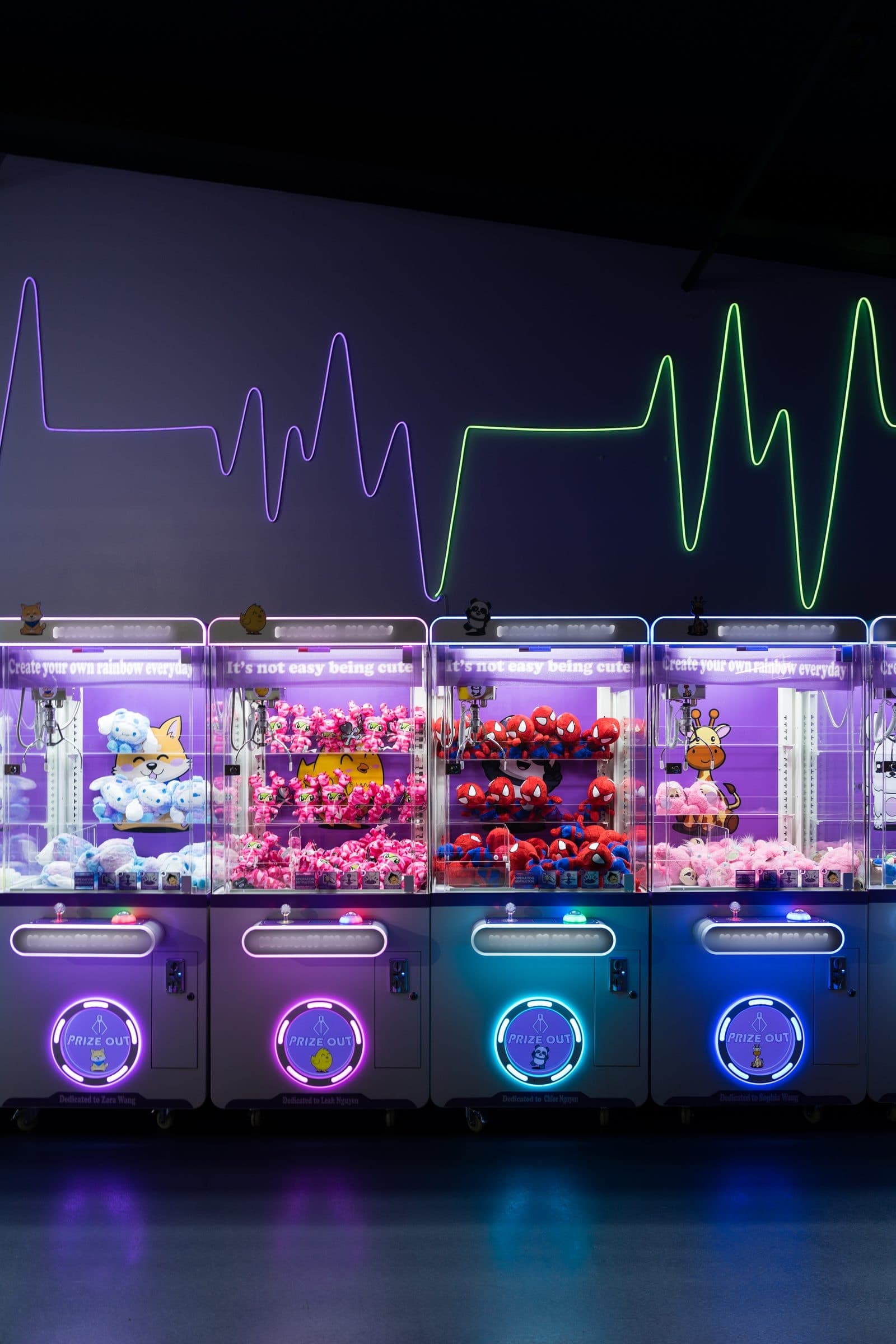 A lineup of pastel-lit claw machines filled with plush characters.